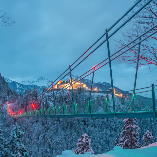 Beleuchtete Hängebrücke highline179 mit beleuchteter Burgruine Ehrenberg im Winter