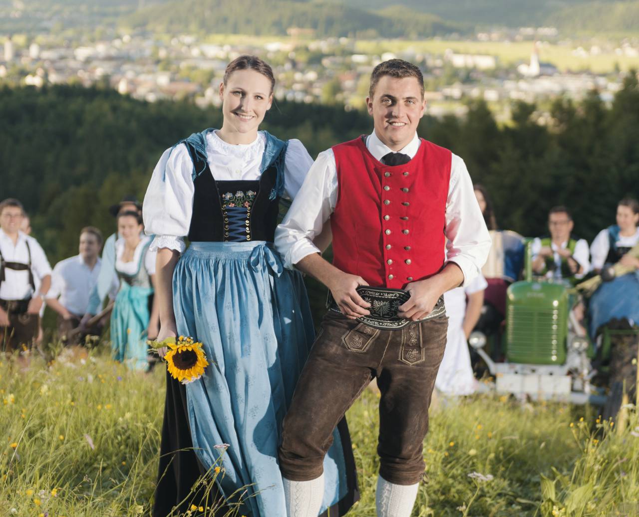 Traditional couple on a summer meadow with view over Reutte and the Alps