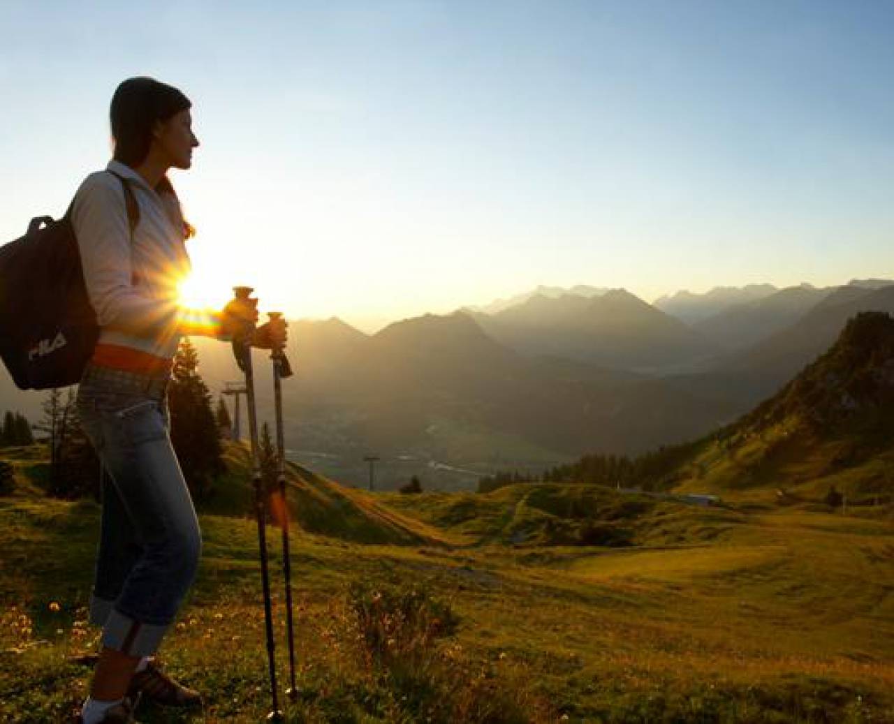 Wandelaarster geniet van zonsondergang in Alpenlandschap