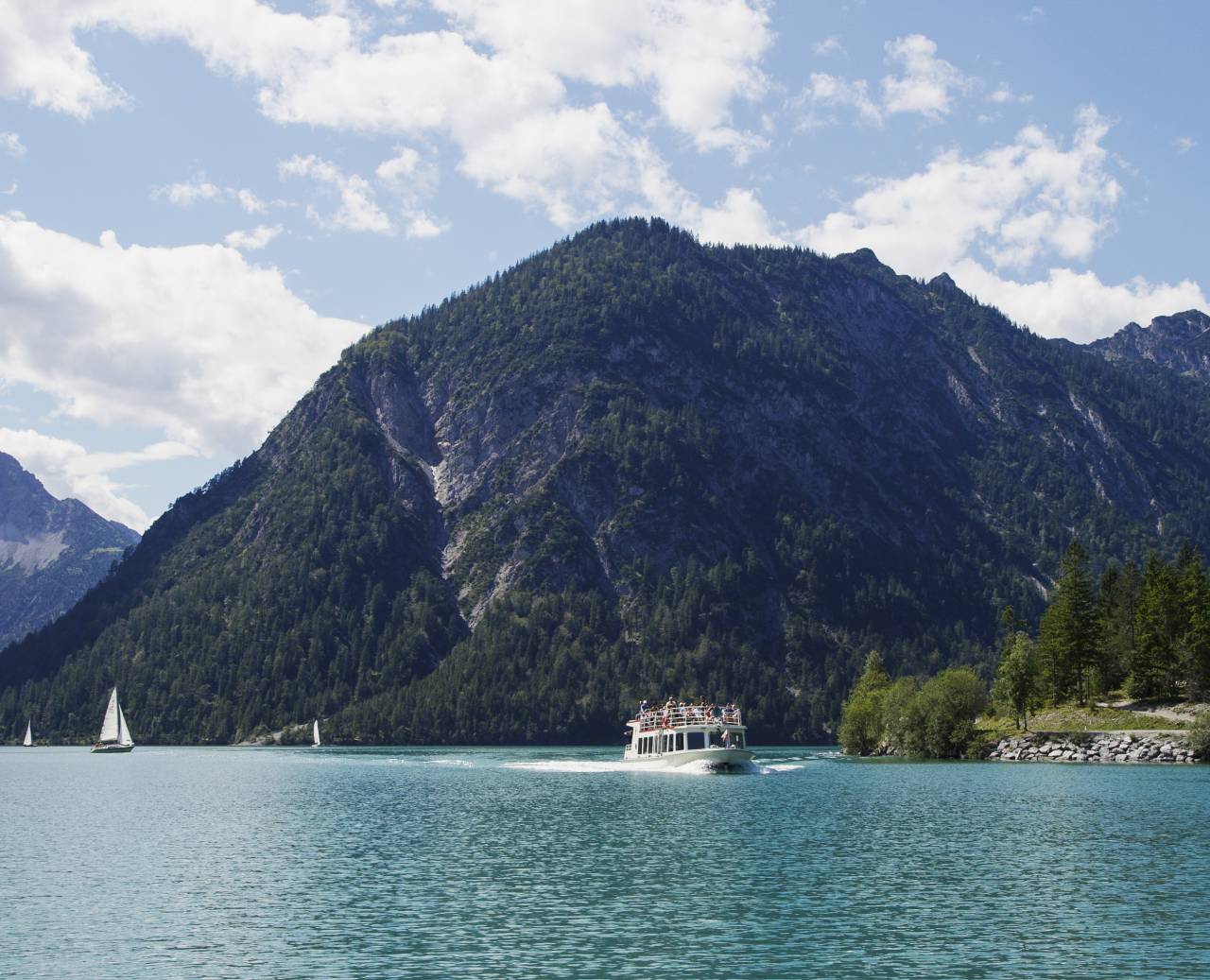 Ship and sailboats on the Plansee in summer