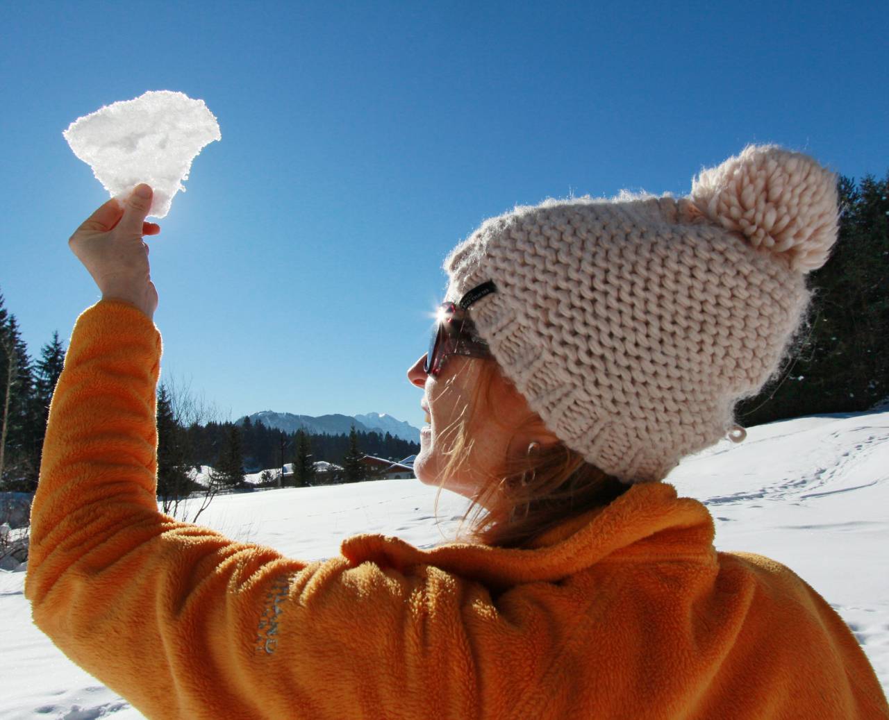 Vrouw bewondert een sneeuwsculptuur in de zon
