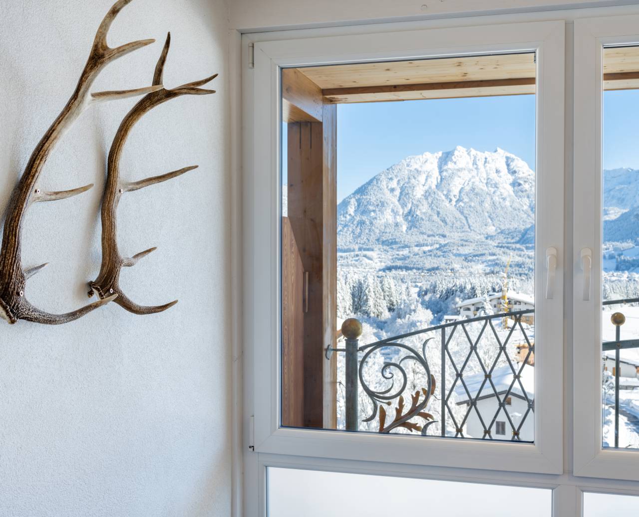 Uitzicht op besneeuwde bergen met gewei-decoratie aan de muur