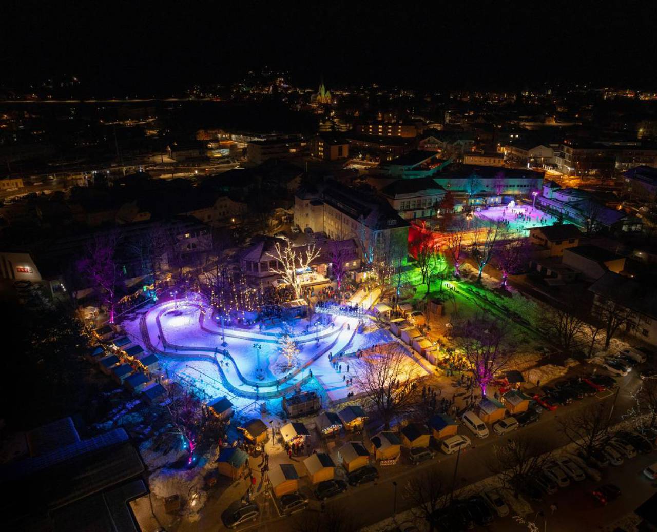 Colorful winter lights on skating rink and stalls in the city