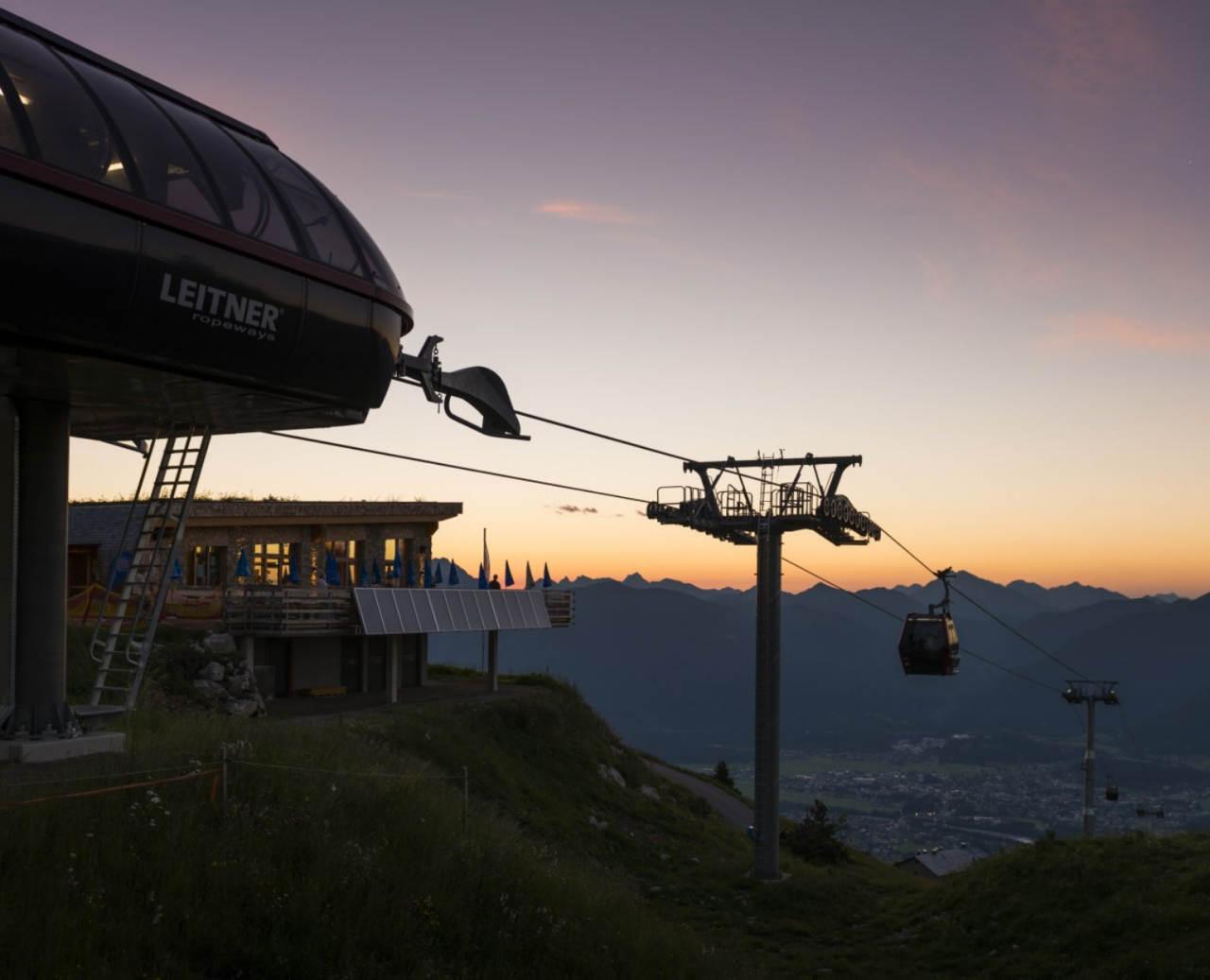 Cable car station with gondolas at sunset in the mountains