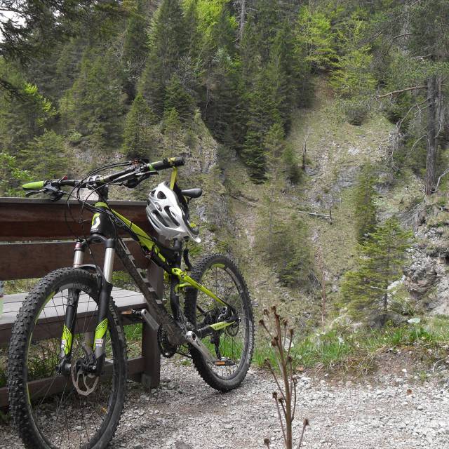 Mountain bike with helmet at a forest rest stop overlooking a steep gorge