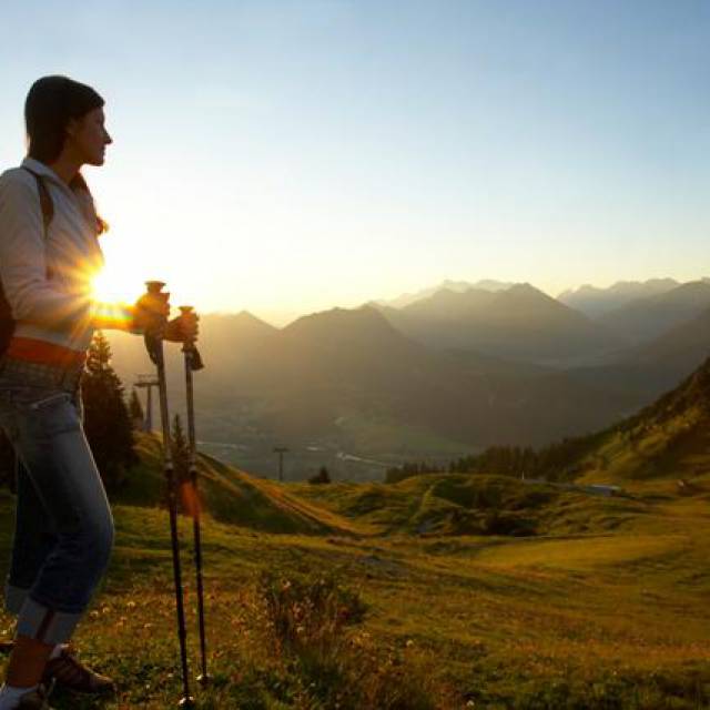 Wanderin genießt Sonnenuntergang in alpiner Berglandschaft