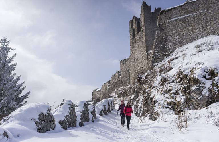 Zwei Frauen entdecken bei einer Winterwanderung die Burg Ehrenberg bei Sonnenschein