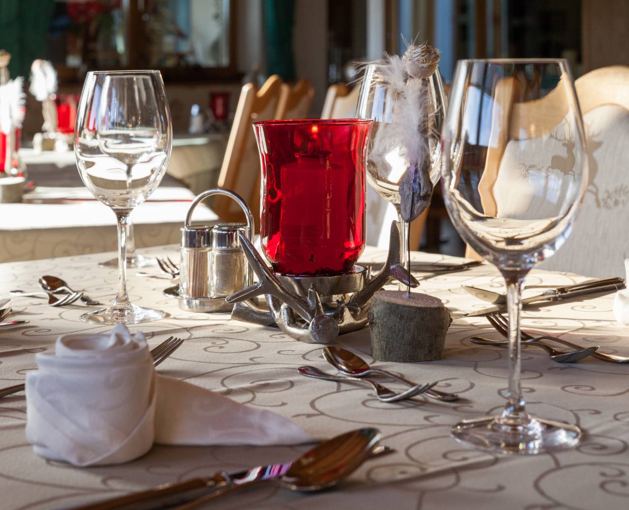 Festively decorated tables with candles, wine glasses and napkin flowers
