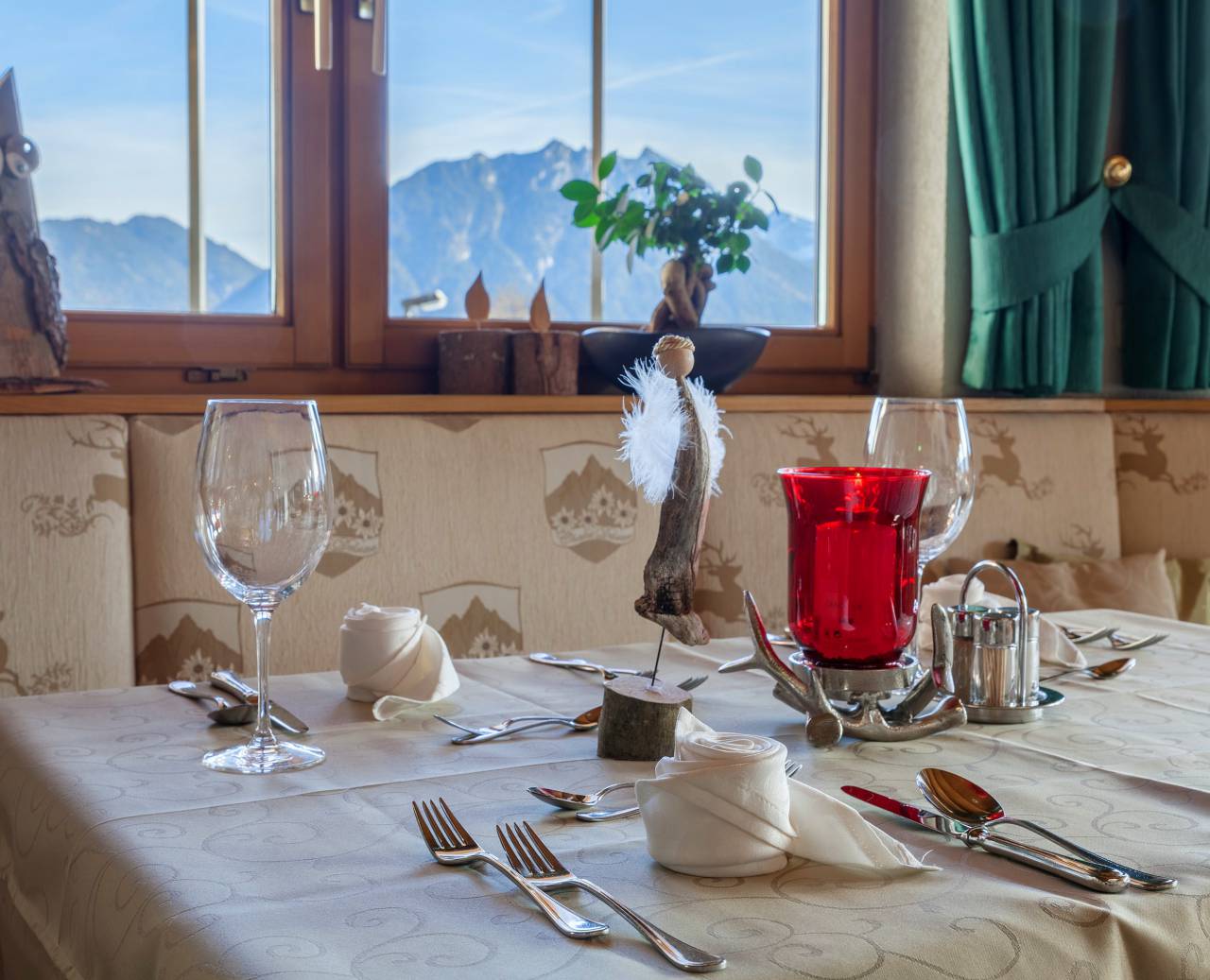 Festively decorated tables in the restaurant with candles, wine glasses and napkin flowers