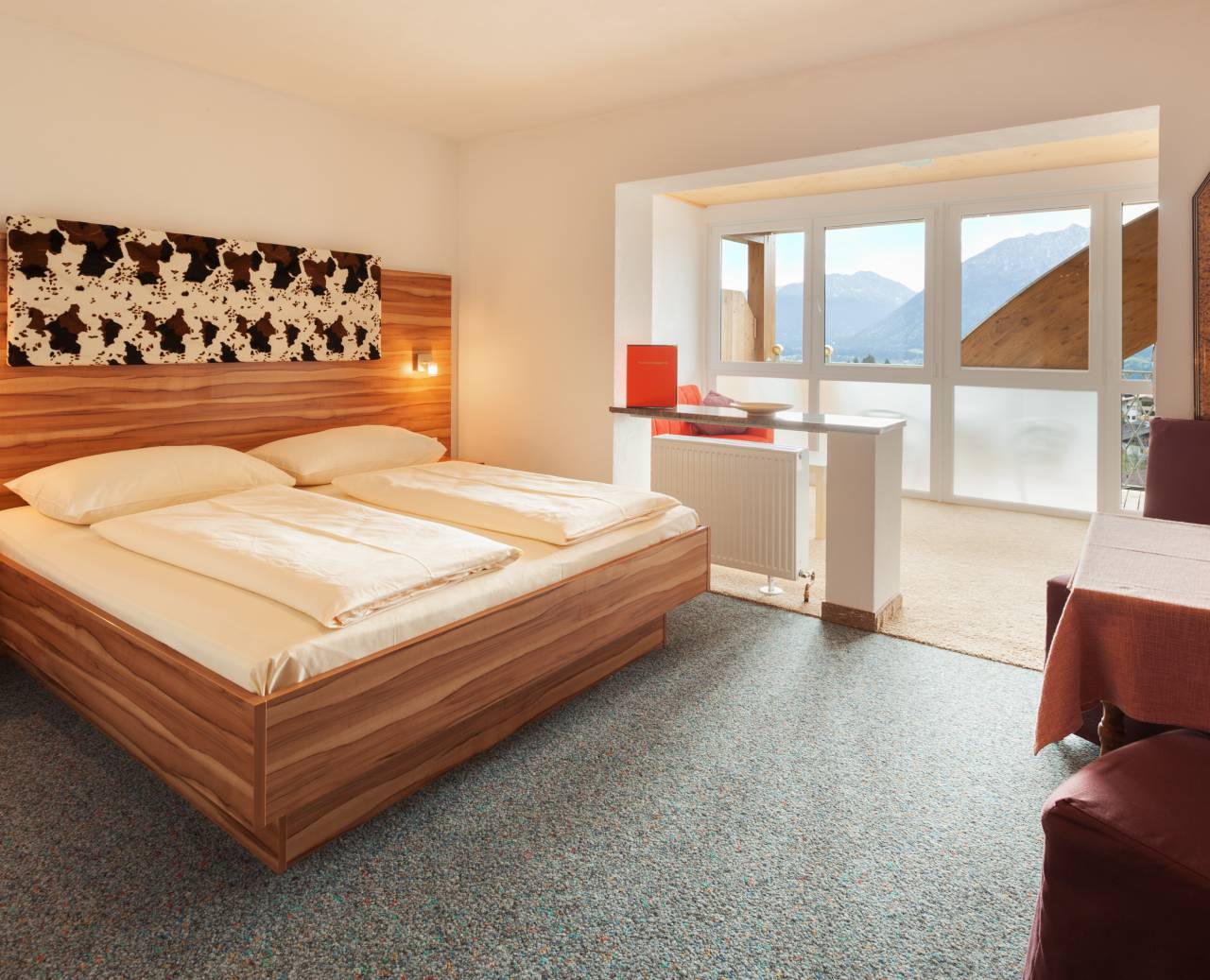 Hotel room with large double bed, seating area, living room and balcony