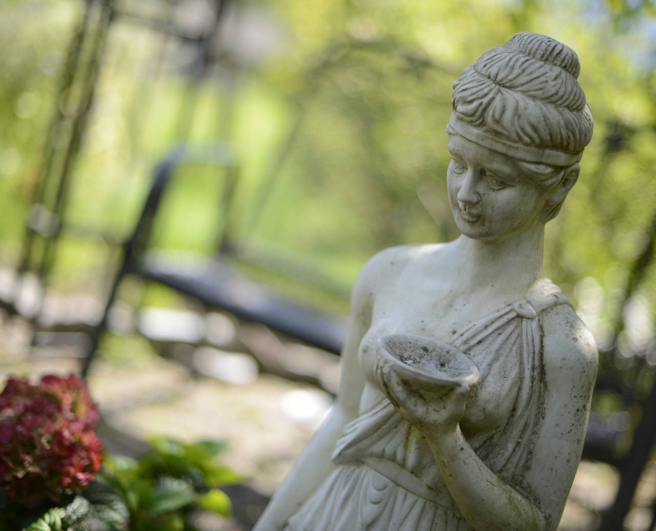 Kleine Statue einer Frau aus Stein im Garten