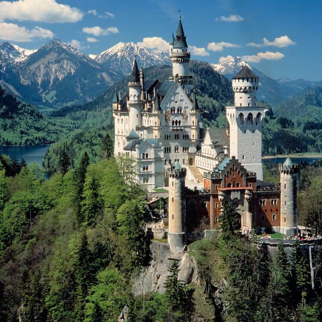 Neuschwanstein Castle with a view of the snow-covered mountains