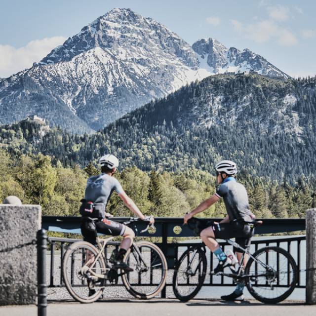 Cyclists taking a break with a view of the snow-covered mountains