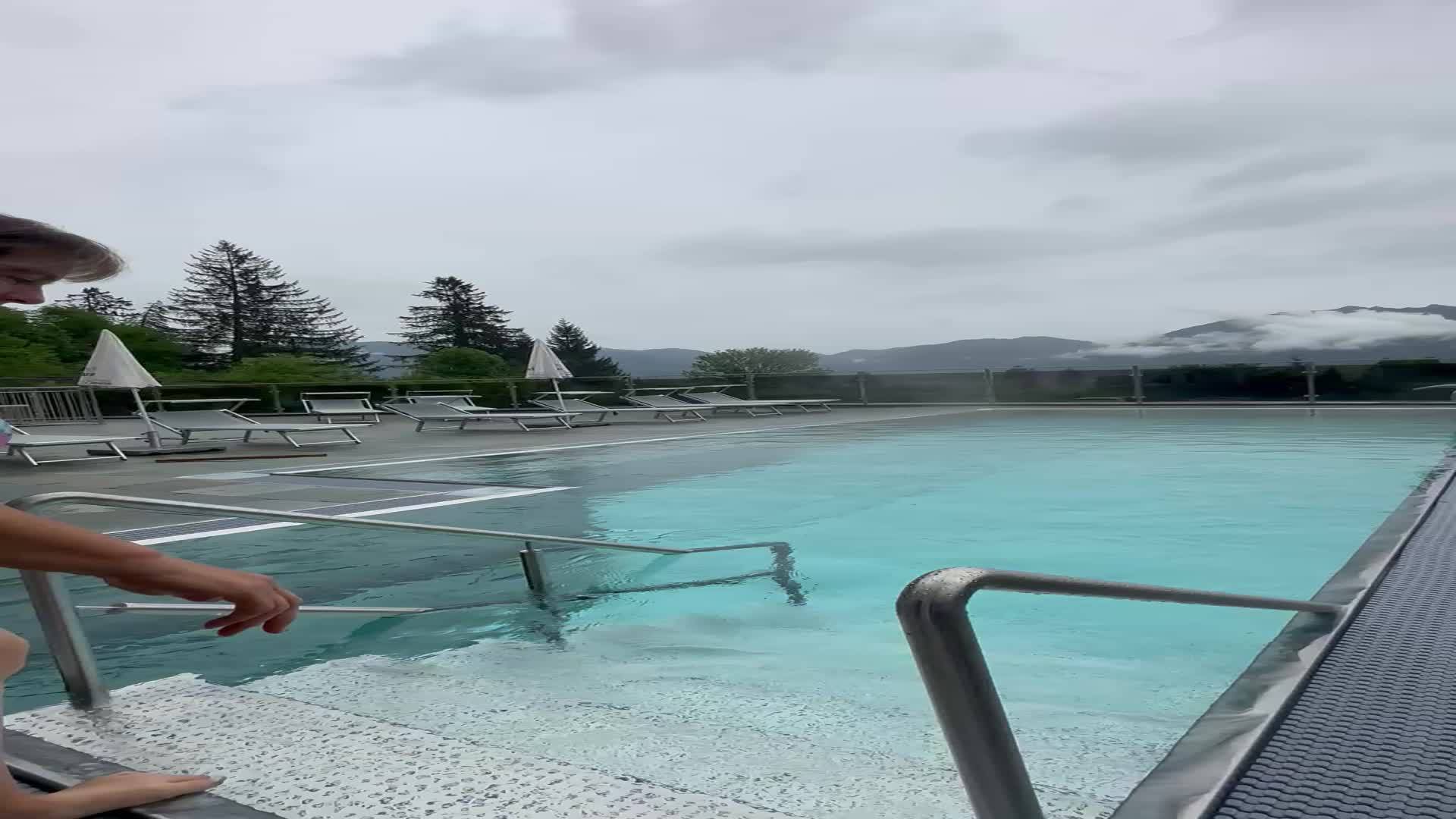Eine Frau genießt das Schwimmen im Hotelpool, auch wenn es regnet