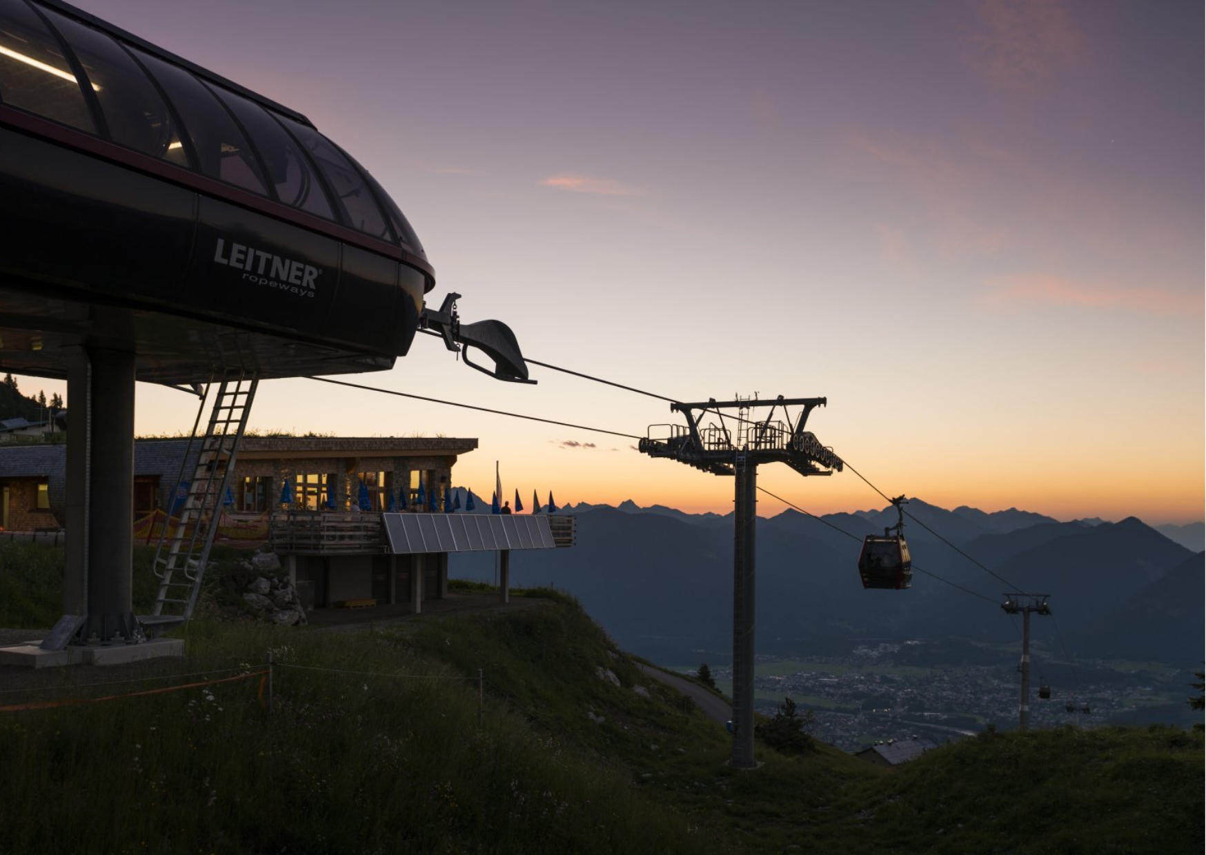 Cable car station with gondolas at sunset in the mountains